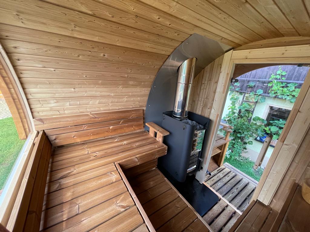 Innensicht der Fasssauna ALEX DE LUX mit hochwertigem Holz und stilvollem Ofen für entspannende Saunamomente.